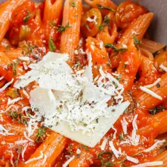 Szybki obiad z makaronem penne w sosie pomidorowym, z oliwkami i parmezanem. Idealny na szybki posiłek.