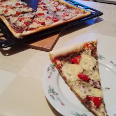Domowy przepis na pizzę z serem i papryką. Jedna porcja na talerzyku, reszta na blasze.