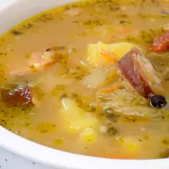 Gęsty, sycący kapuśniak z kawałkami wędzonego mięsa, ziemniakami i marchewką. Aromatyczny, domowy smak.