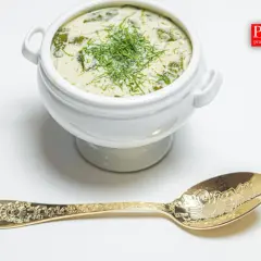 Aksamitna zupa królewska, ozdobiona koperkiem, czeka na złotej łyżce. Prawdziwie domowa kuchnia.