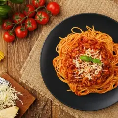 Apetyczne spaghetti bolognese z parmezanem i bazylią. Idealne jakie przyprawy do spaghetti? Zioła, czosnek, pomidory.