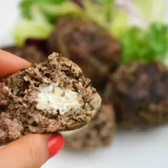 Soczyste bifteki z serem feta w środku, podane z sałatką.