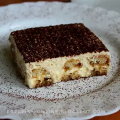 Pyszne tiramisu, czyli zabajone, na białym talerzu, posypane kakao. Idealne na deser.