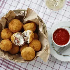 Arancini co to? Złociste kulki ryżowe z serem i wędliną, podane z sosem pomidorowym. Pyszna przekąska!