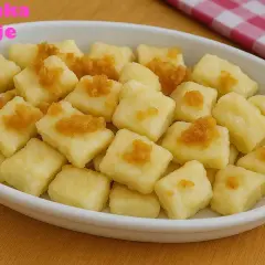 Mięciutkie kluski leniwe, przygotowane przez Halinkę, podane w białej misce, posypane rumianym cukrem.