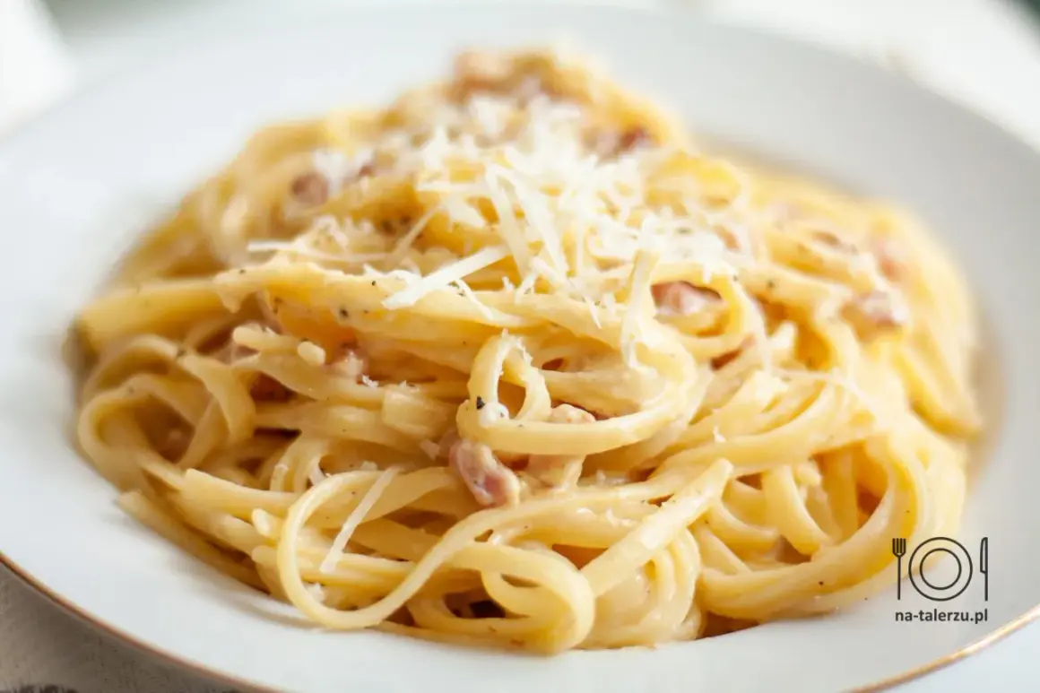 Pyszne spaghetti carbonara, przygotowane według oryginalnego przepisu ze śmietaną, posypane startym parmezanem.
