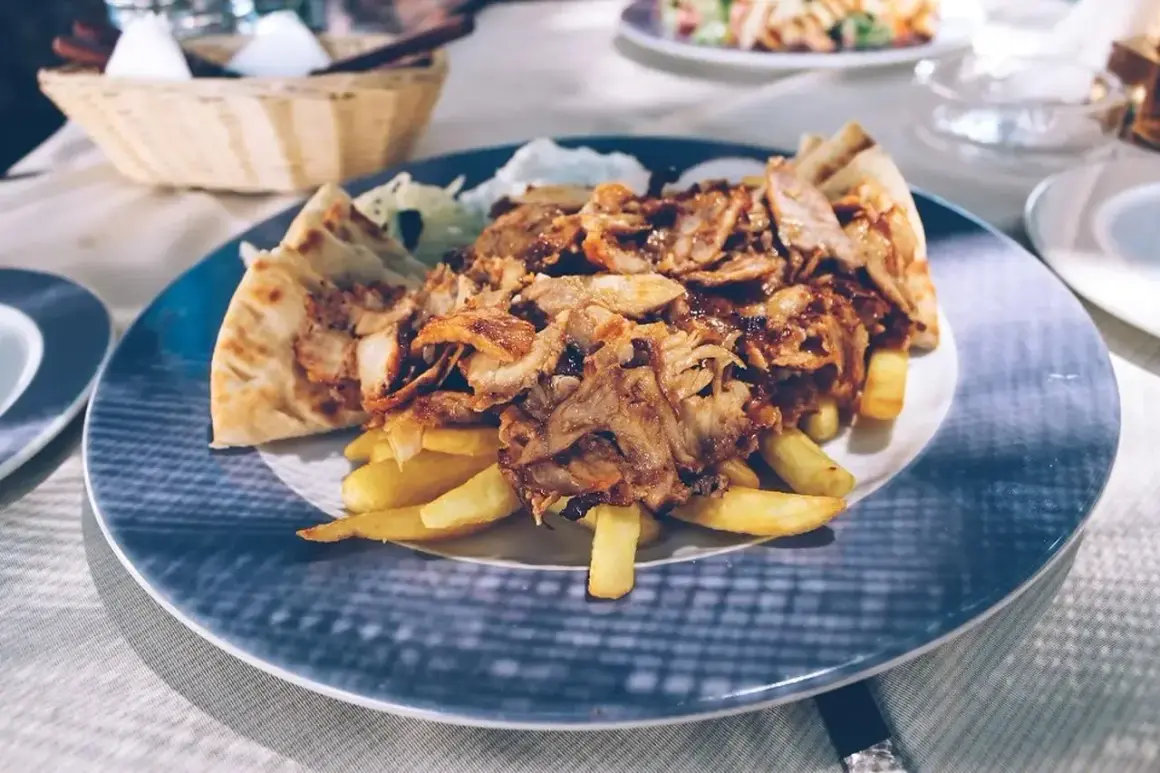Pyszna shoarma co to? Mięso z kurczaka, frytki i pita na talerzu.