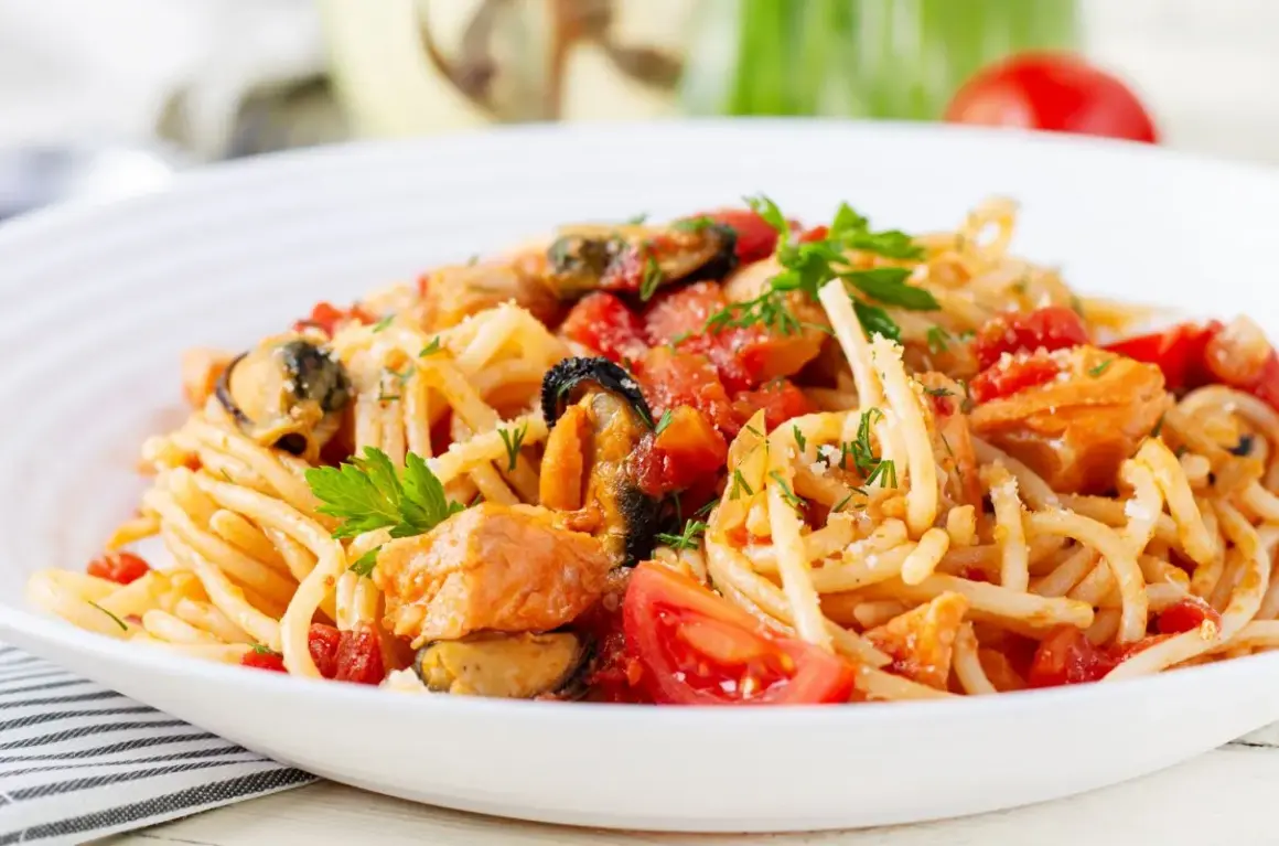 Pyszne spaghetti z owocami morza, pomidorami i świeżą natką pietruszki.