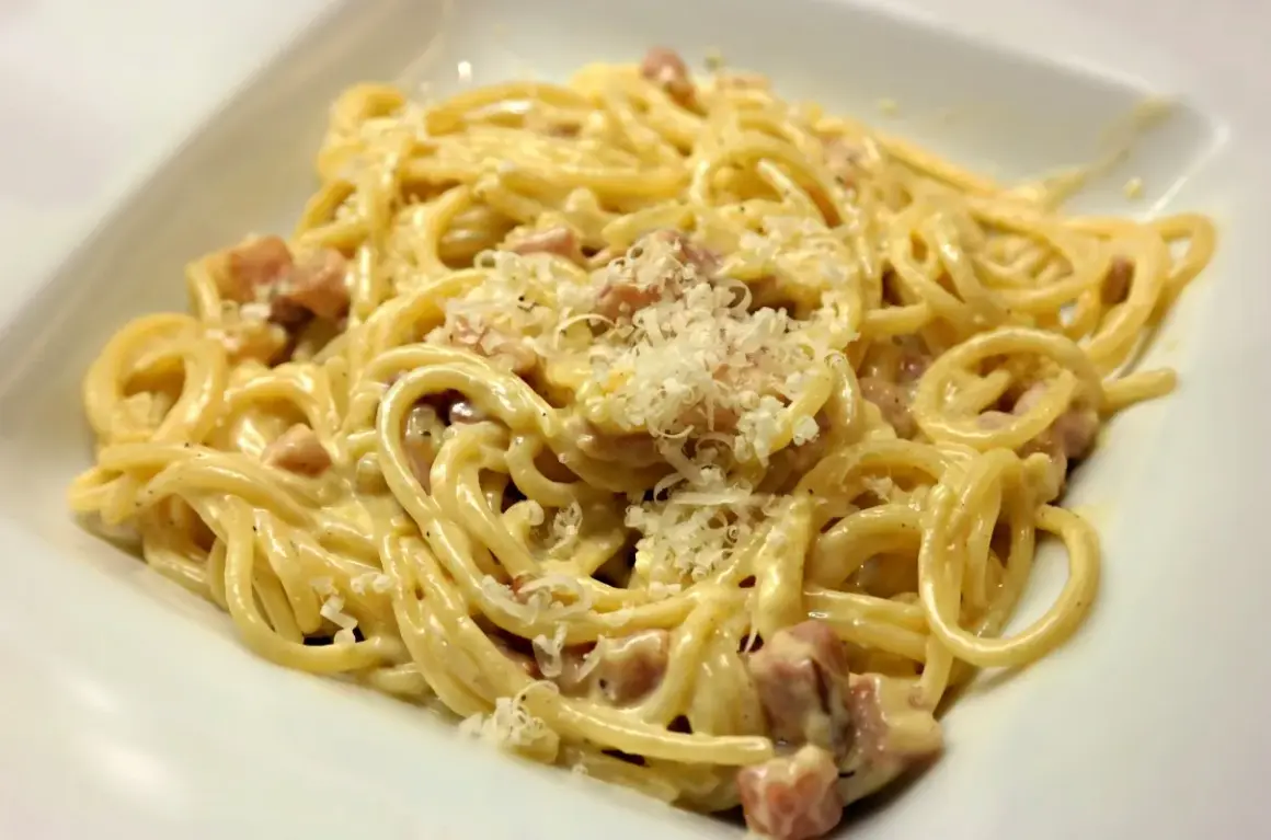 Pyszna carbonara z boczkiem, kremowy sos, parmezan i idealnie ugotowany makaron spaghetti.