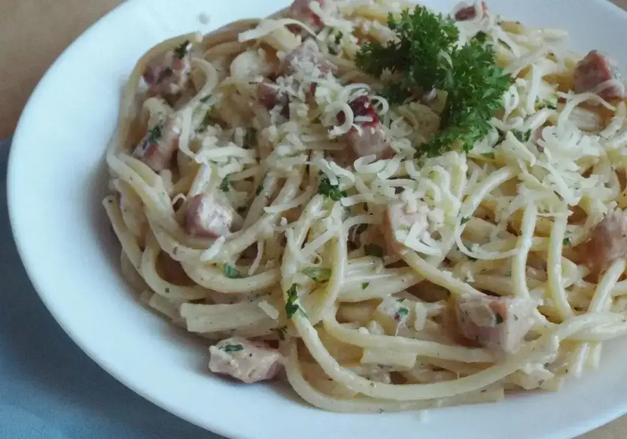 Pyszna carbonara z kawałkami boczku, posypana parmezanem i natką pietruszki. Idealna do tej potrawy jest śmietana 30%.